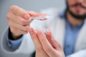 dentist in Katy TX showing Invisalign clear aligners during consultation
