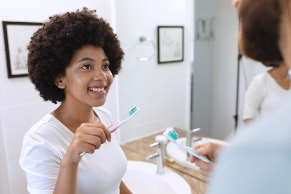 patient brushing teeth to maintain healthy oral hygiene in Katy TX