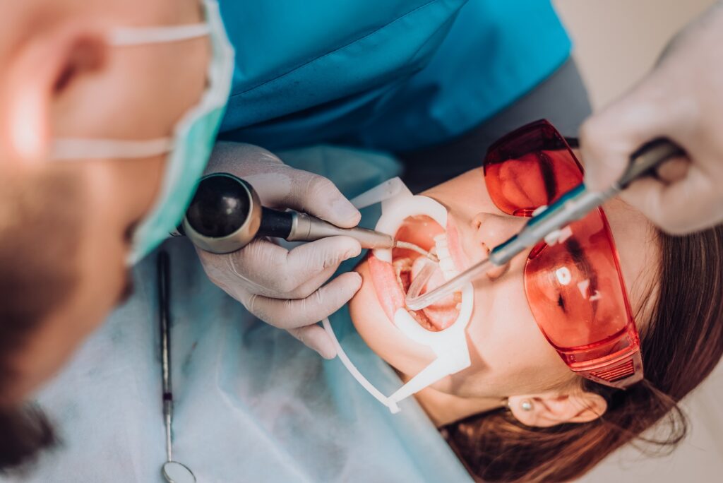 dentist performing professional teeth whitening treatment in Katy TX